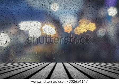 old wooden floor platform with rainy drops water on glass