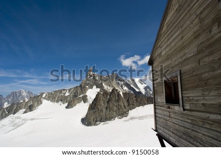 A weathered cable car station in Chamonix, France looks out onto the snow covered alps.
