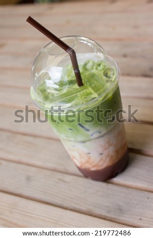 milk green tea smoothie in plastic cup on table.