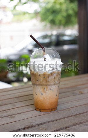take-home cup of ice coffee on table.