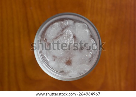 cold glass of water and ice rocks. top view, soft focus.