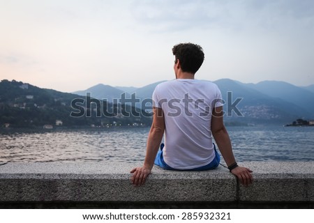 The young man looking at the beautiful view at the lake