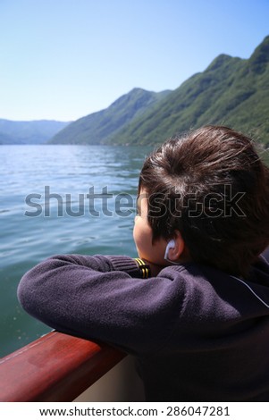 Little boy on the boat tour looking at the views at the lake Como