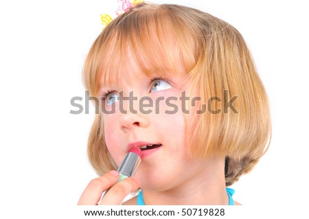 Cute little girl is painting her lips