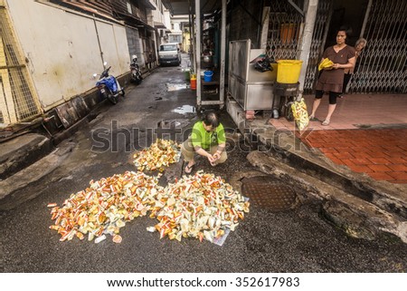 George Town, Penang, Malaysia - 20 April 2013: Chinese burning a ghost money in front of his shop in George Town on April 20.
