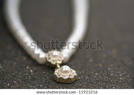 Close up on old pearl necklace on grey glittering background