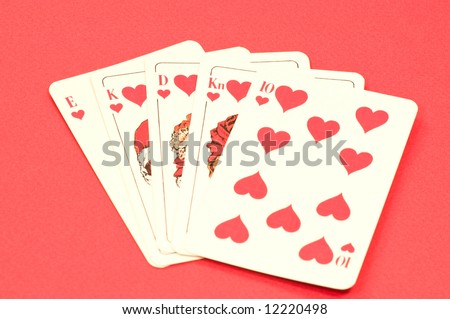 Play cards shows a winning hand, royal flush on red textured background