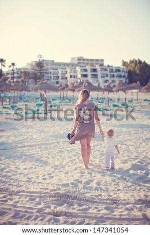 mother and daughter walking at the beach
