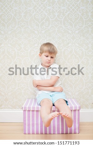 sad boy sitting on the box