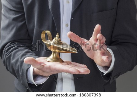 corporate man hands holding Aladdin lamp for making a wish