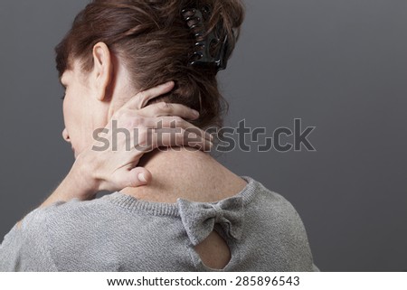 50s woman with tension and fatigue in neck relaxing her muscles