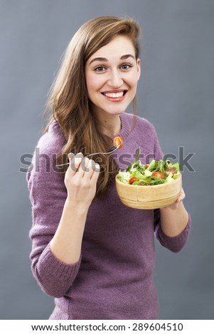 thrilled beautiful young woman eating mixed salad for healthy diet and good food