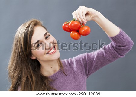 happy gorgeous young woman holding grape of tomatoes for veggie health and good nutrition