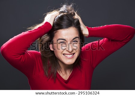 raging 30s brunette girl losing temper, screaming loud with hands tearing hair out on black background