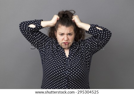 furious overweight 20's woman losing temper, tearing hair out for exasperation and frustration