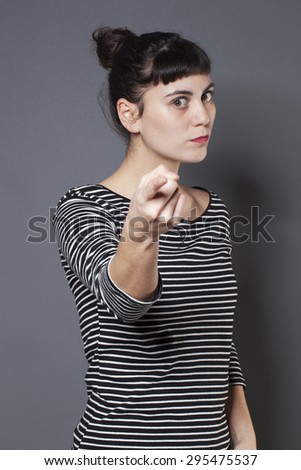 blaming young brunette woman staring at someone with index finger forward accusing and condemning someone with severity