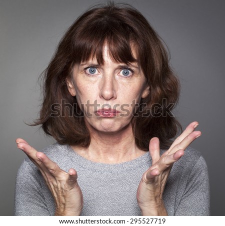 closeup portrait of frustrated 50\'s woman losing faith, pouting with palm hands opened for resignation