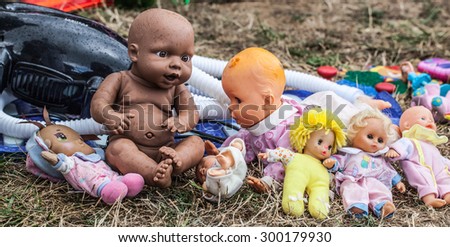 display of old dolls and baby dolls in plastic and fabric sold at flea market for antique collection
