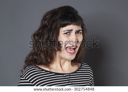 fear concept - disgusted 20s woman with brown hair looking scared,studio shot