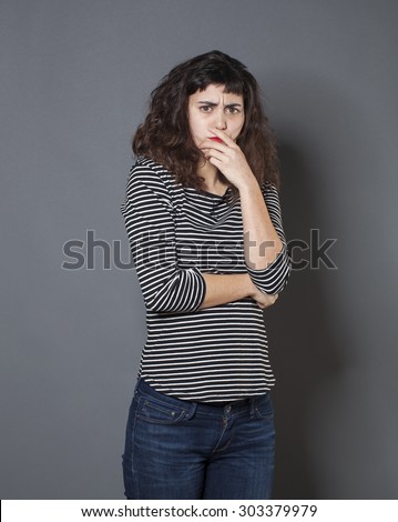 doubt concept - thinking 20s woman with brown hair mad at having forgotten something,looking unhappy,studio shot