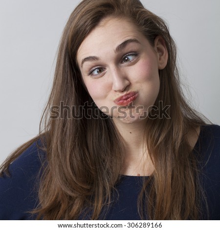 humor concept - portrait of a cross-eyed young woman pouting,having fun in practicing a funny face with her eyes
