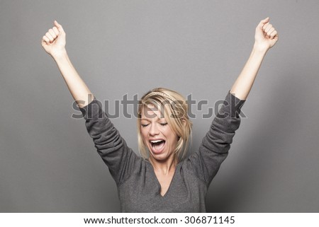 success concept - laughing young blonde woman winning a competition with fun sexy body language