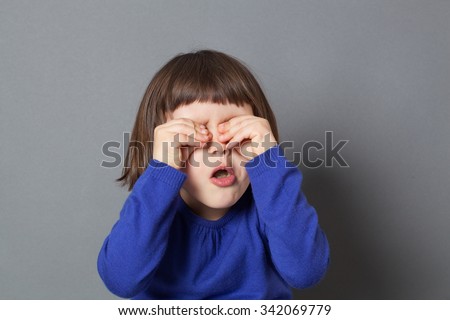 kid fun concept - cheeky preschool child playing peekaboo or hide and seek,rubbing eyes to be invisible for fun game,studio shot