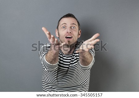 body language concept - excited 40s man enjoying reaching a product or something in front of him with focused hand gesture,studio shot on gray background