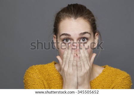 negative feelings concept - shocked beautiful 20s girl covering her mouth and nose with hands for emotions or bad odor,studio shot on gray background