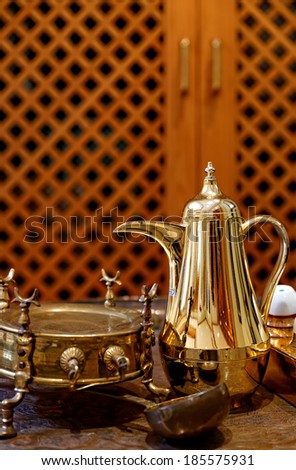 Classic luxurious Moroccan Tea or coffee pot.  Background has a wooden window out of focus.  Also famous in Turkey, Egypt and middle east.  Symbols the hospitality in the Middle east and Arab world.