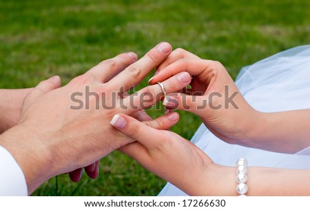 fiancee puts a ring on a finger to fiance