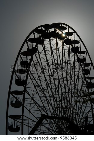 A big ferris or observation wheel in the amusement park against the sky at the sunset in black and white