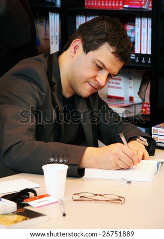 PARIS - MARCH 15: French fiction writer Guillaume Musso dedicates his books at the International Book Fair - Salon du Livre 2009 on March 15, 2009 in Paris, France