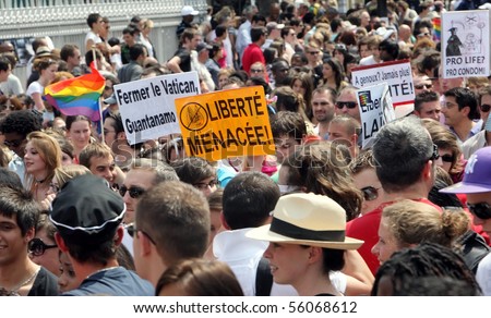 PARIS - JUNE 26: 800,000 people march in the Paris Gay Pride parade to support gay rights, on June 26, 2010 in Paris, France. The posters say \'Close the Vatican\' and \'Threat to freedom\'.