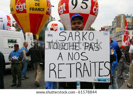 PARIS - SEPTEMBER 23: A man holds the poster \'Sarkozy don\'t touch our retirement\' during France\'s nationwide strike against the raise of the retirement age on September 23, 2010 in Paris, France