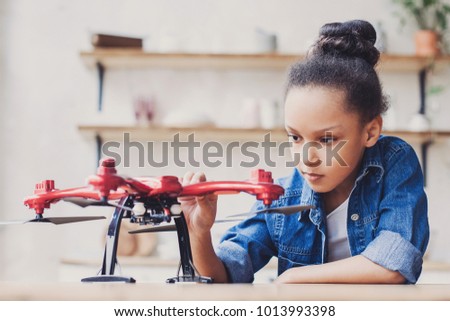 Young cute girl holding quadcopter. Child playing with drone. Education, children, technology, science, future and people concept