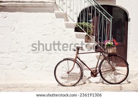 Old bicycle with a basket leaning against a wall in Italy