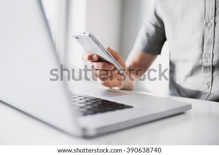 Close up of a man using mobile smart phone, a business man hands busy using cell phone at office desk