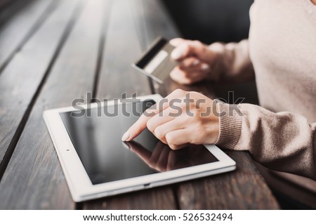 Hands holding credit card and using digital tablet. Online shopping concept