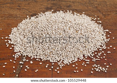 organic white chia seeds rich in omega-3 fatty acids - superfood - on a grunge wood surface