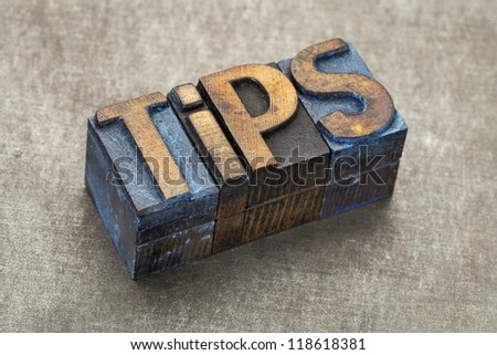 tips word - text in vintage letterpress wood type blocks against a grunge metal background