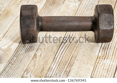 vintage iron rusty dumbbells on weathered white painted barn wood background - fitness concept