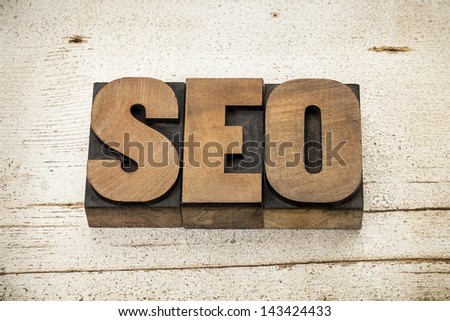 SEO acronym (search engine optimization) - a word in vintage letterpress wood type on a grunge painted barn wood background