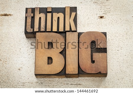 think big - motivation concept in vintage letterpress wood type on a grunge painted barn wood background