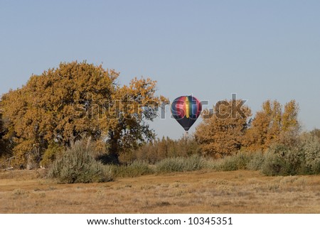 hot air balloon over horizon preparing to land in dry south eastern Colorado (Arkansas River Valley) in a late autumn, clear sky, copy space