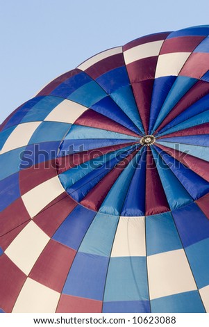 top of hot air balloon with white, purple and blue ring patterns being inflated