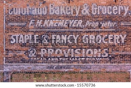 Old advertisement of bakery and grocery store on a brick building wall in historic downtown of Fort Collins, Colorado