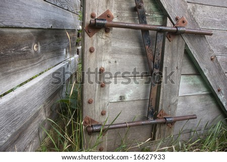 wooden gate with a metal lock and fence in an old cattle ranch