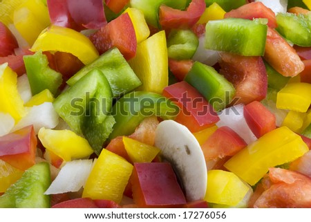a mixture of green, red, yellow bell pepper, onion and mushrooms diced and ready for cooking or salad