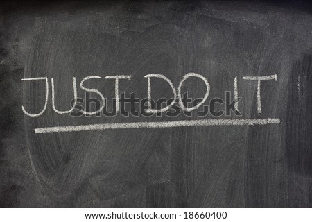 Motivational phrase, just do it, handwritten with white chalk on a blackboard